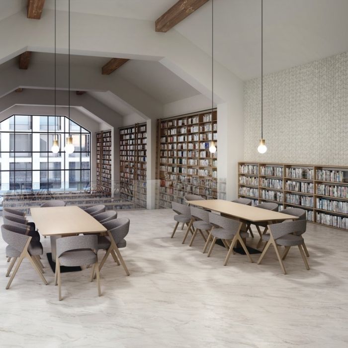 Spacious library with Daltile's3x6 Iconic Chevron Polished White Porcelain Tiles on its walls, providing a timeless backdrop for bookshelves.