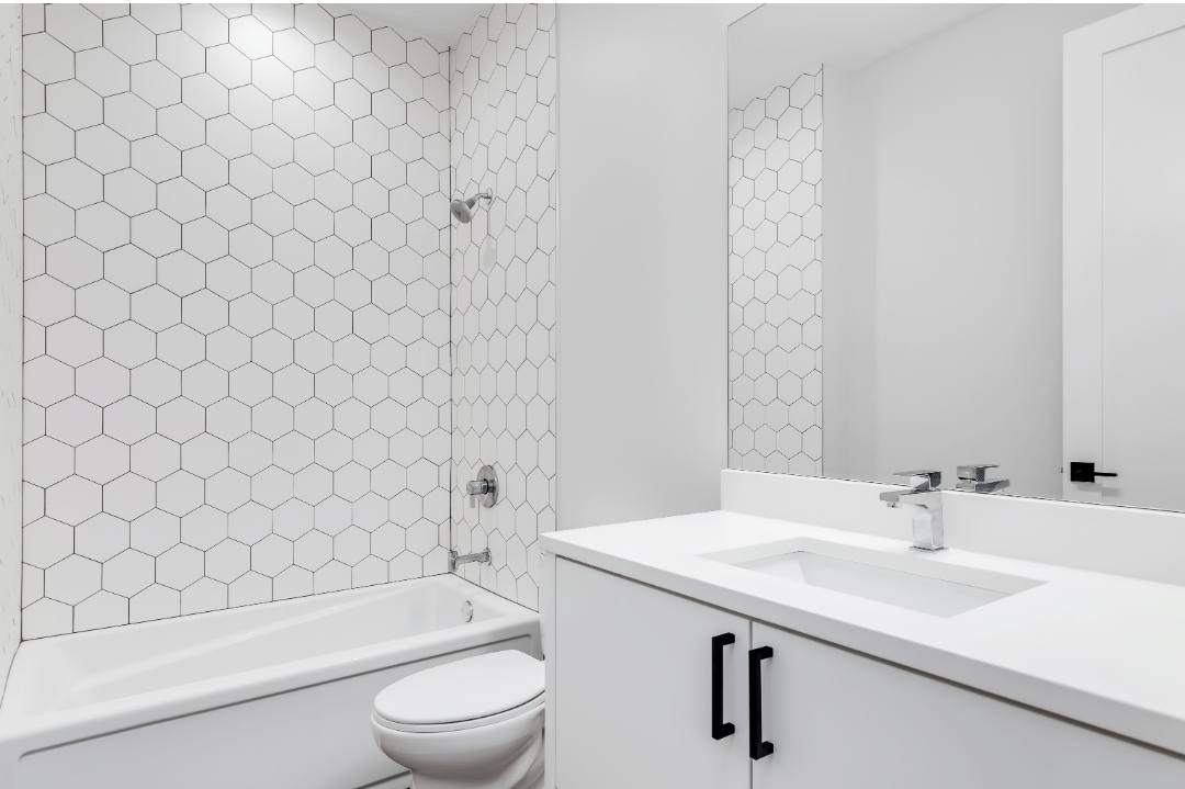 Hexagon tiles with black grout create a stark contrast on a modern all-white bathroom