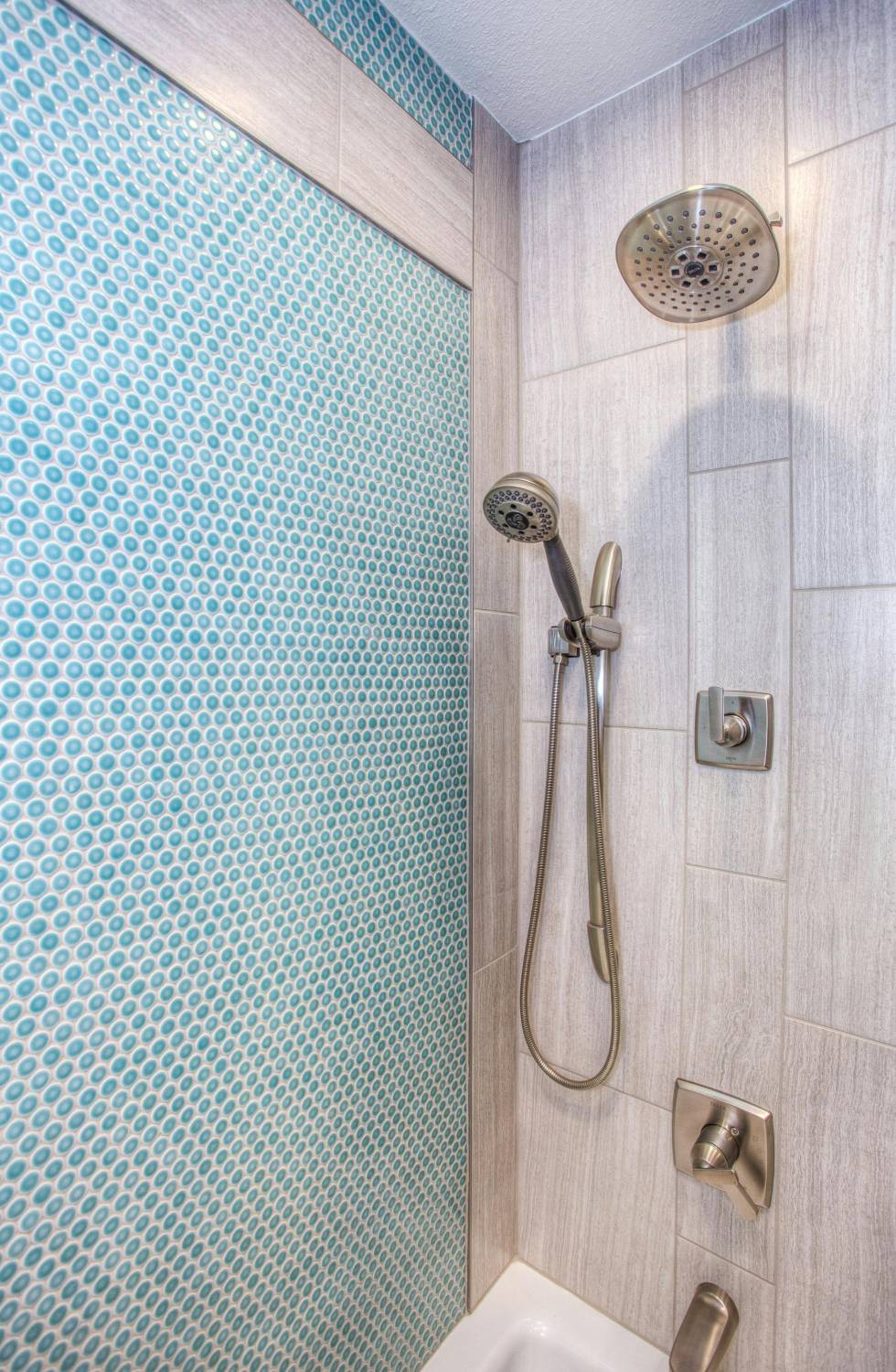 Green penny tile pattern on a small shower wall