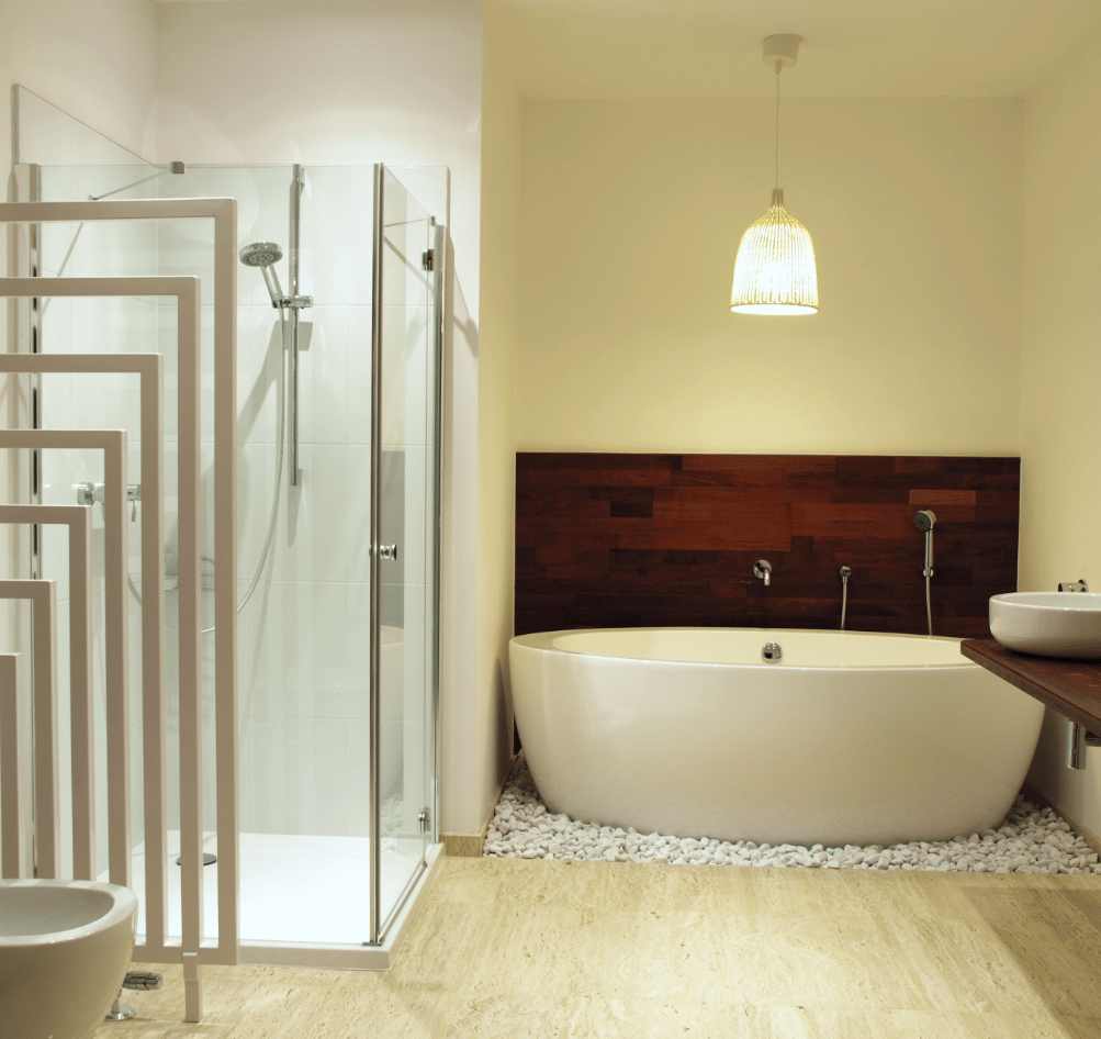 Bathroom with travertine floors and a bathtub surrounded with pebbles 