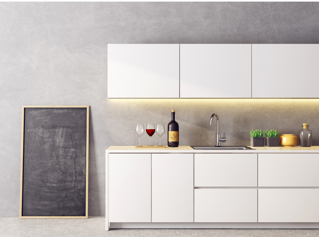 A modern industrial kitchen with a white countertop, large concrete backsplash, white cabinets.