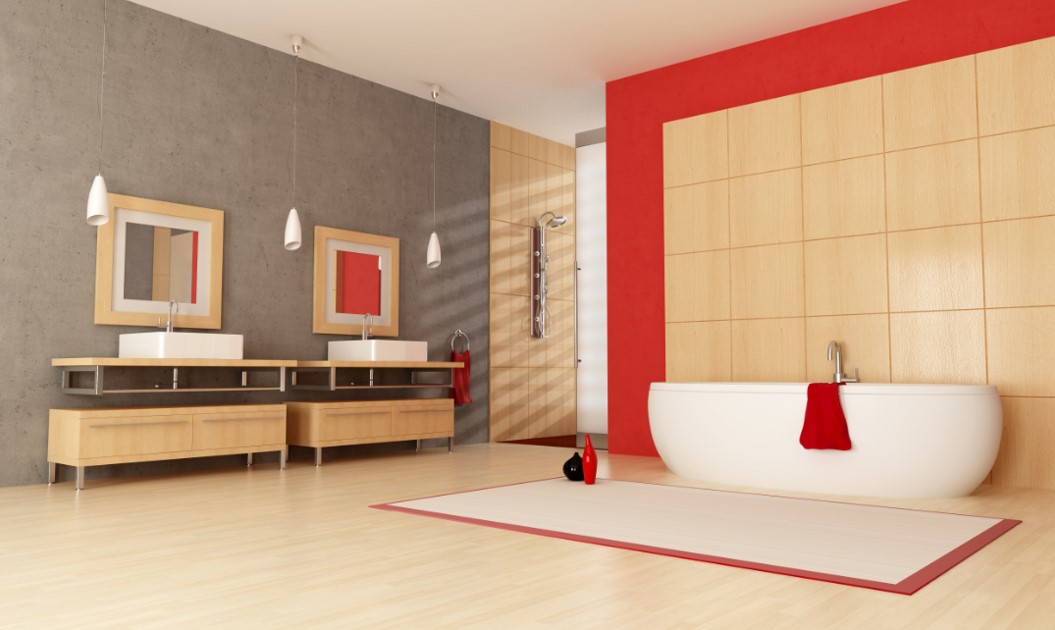 A contemporary bathroom with wood-look floors. Behind the white bathtub are walls made from wood-look porcelain tiles, painted with red borders. On the other side of the wall are concrete-looking wall accents.