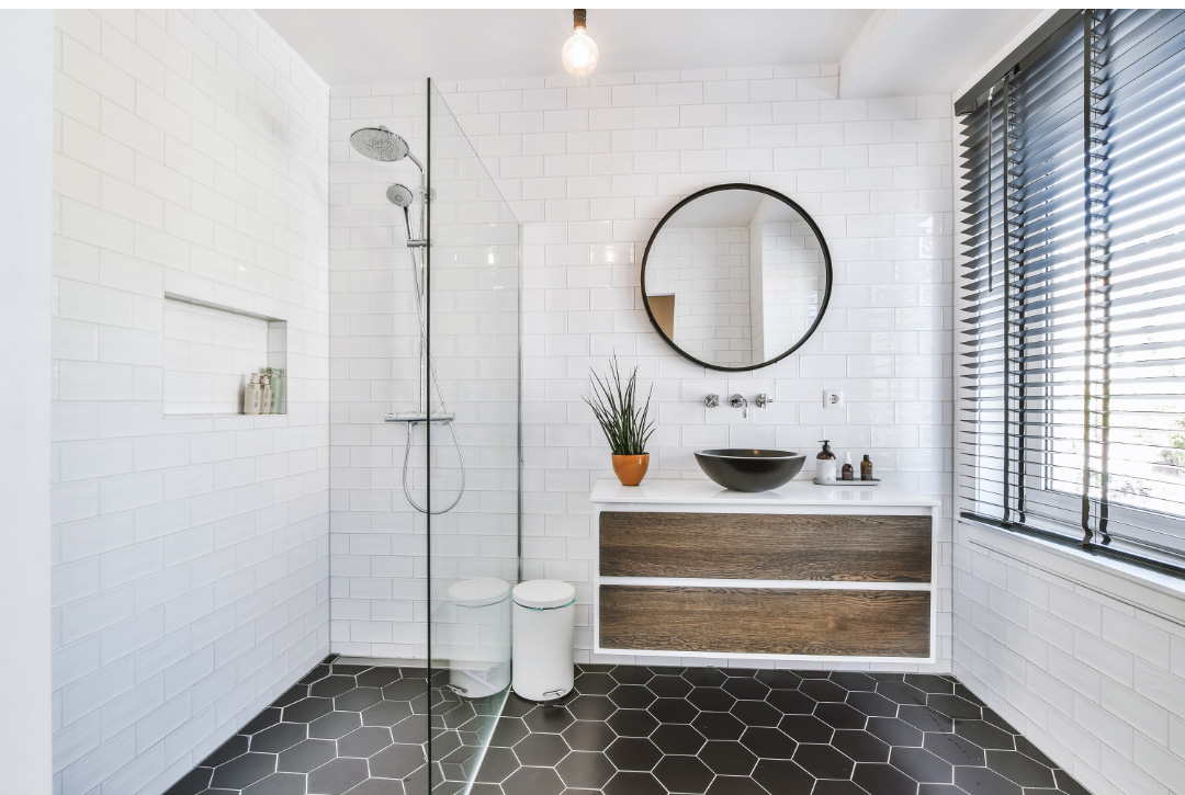 Black mosaic floor tiles in a white minimalist bathroom space