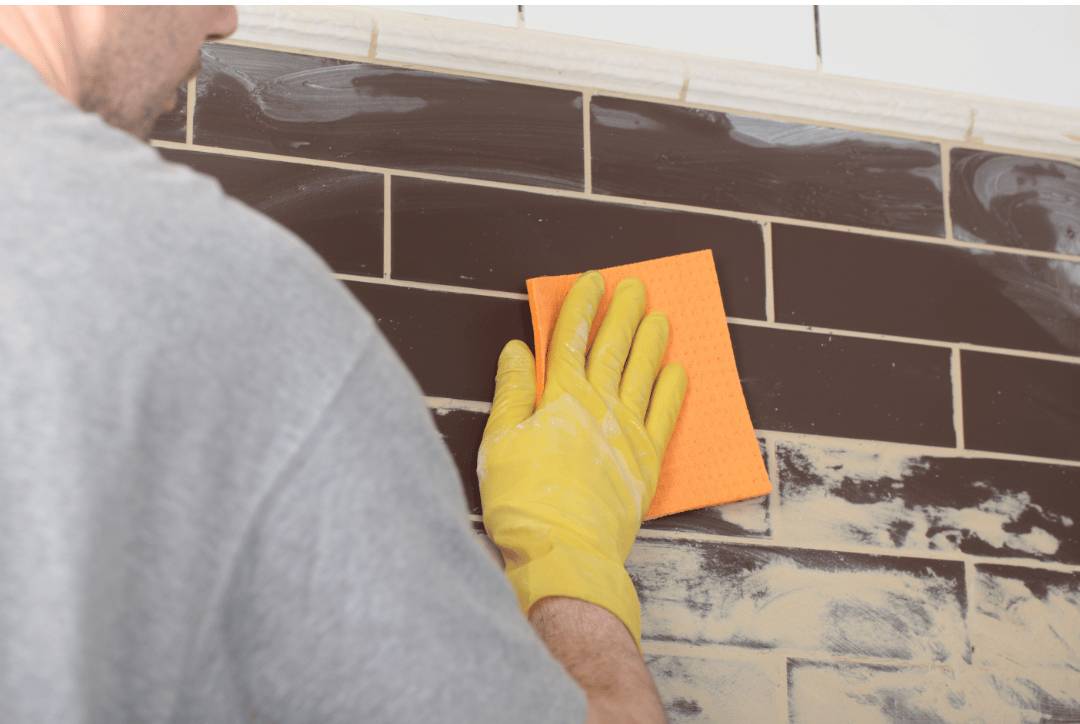 Finishing and cleaning grout excess on brown subway tiles