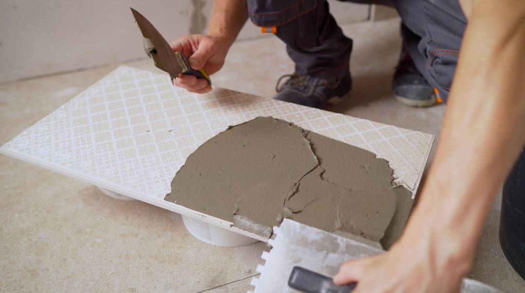 Mixing cementitious grout with water for tile installation.