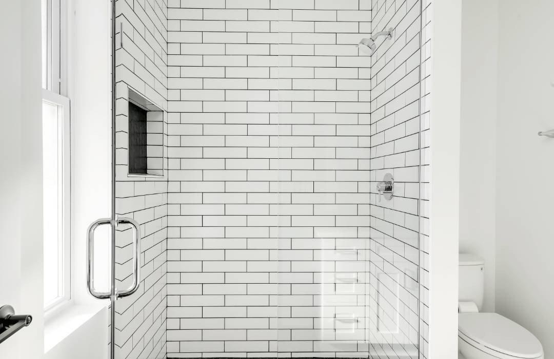 3x12 Matte Arctic White Rectangle Undulated White subway tiles with black grout on a shower wall.